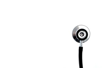 On a white isolated background lies a black stethoscope.