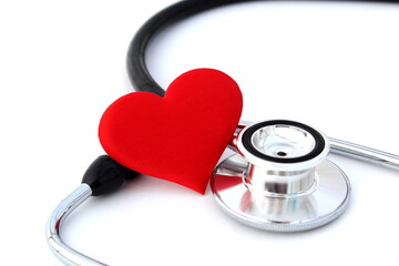 On a white background lies a stethoscope and a red heart.