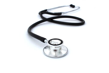On a white isolated background lies a black stethoscope.