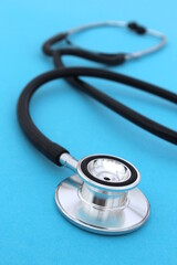  The stethoscope lies on a blue bright background.