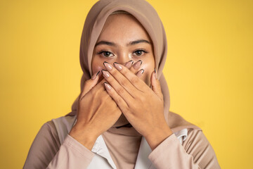 muslim woman with shocked expression with hands covering mouth