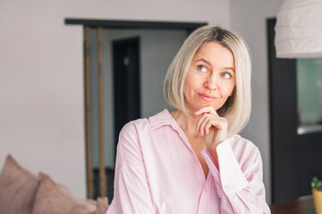Smiling middle aged mature woman looking at camera at home