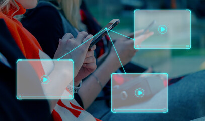 A young woman sits and holds a smartphone in her hands. Internet player window next to smartphone