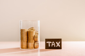 Many gold coins were put in a glass jar and wooden signs with tax messages. Annual income tax...