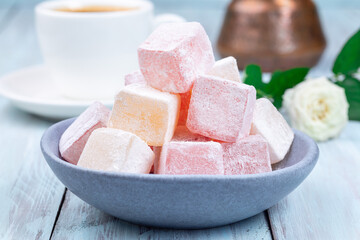Turkish delight or lokum confection rose and lemon flavored with cup of coffee and cezve, closeup