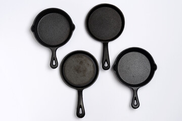 high angle view of cast iron skillets on white background