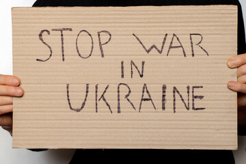 Stop the war in Ukraine written on a sign that a woman holds in her hands from her house in the Dnieper, protest action, martial law