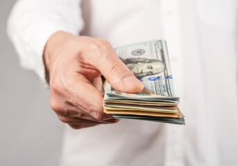 Businessman hand closeup holding US dollars stack. Finance and tax concept. Man receiving or paying salary, debt. High quality photo