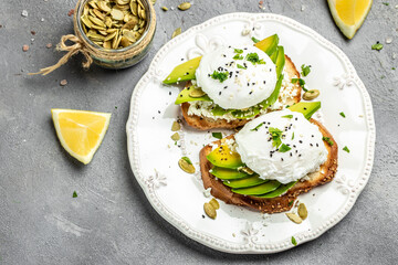 Sandwiches with avocado Poached Eggs. sliced avocado and egg on toasted bread for healthy breakfast or snack. Healthy fats, clean eating for weight loss. top view