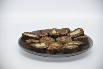 Sweets made from crushed flaxseed with almond filling or whole almond kernel.  Light gray background.