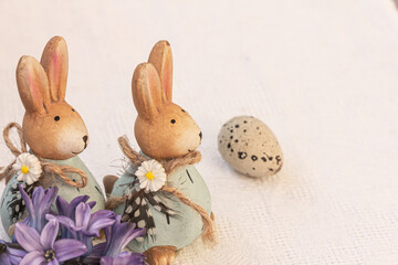 Easter background. Ceramic rabbits, egg and blue hyacinth flowers on white, copy space, mock up.