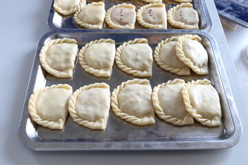 Fototapeta na wymiar Raw curry puffs are on stainless tray before frying in oil, Thailand.