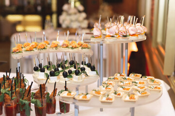 Catering table buffet dinner, beautifully decorated banquet with variety of different food snacks and appetizers on corporate birthday party event or wedding reception, canape, delicatessen setting