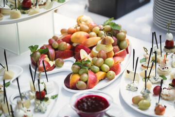 Beautiful wedding candy bar with a lot of sweets, fruits and food. Wedding banquet table