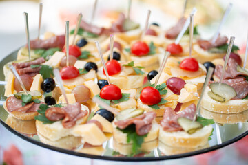 Catering table buffet dinner, beautifully decorated banquet with variety of different food snacks and appetizers on corporate birthday party event or wedding reception, canape, delicatessen setting