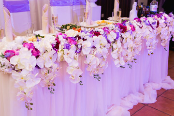 Colorful wedding bouquet of orchids on the restaurant table.