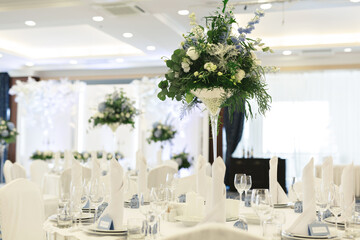 Table setting at a luxury wedding reception. Beautiful flowers on the table.