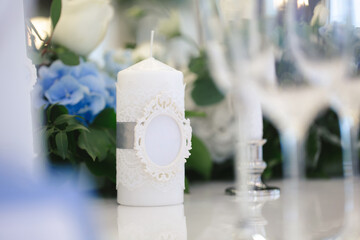 Wedding decor at the banquet. Flowers and candles with the initials of the bride and groom.