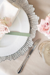 Delicate wedding table setting. A plate with a napkin and a rose.