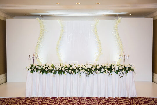 Decorated Wedding Table In The Restaurant, Flowers And A Lavish Chandelier.