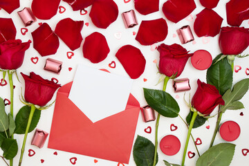Composition of red roses, chocolates, sequins hearts, envelopes, candles on a white background. Content for Birthday, Valentines Day, Womens day, Mothers day. Flat lay, top view, close up, copy space