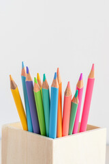 Fototapeta premium Several pastel colored pencils in wooden holder close-up