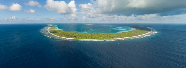 Aerial panorama of yacht and tropical Pacific Atoll
