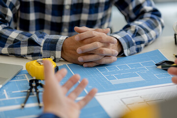 Two people are discussing the design of the building plan, the architect engineer designs the house and interior and draws the floor plans through the design program. Architect building design.