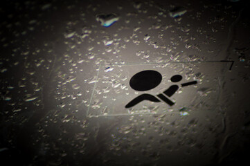 Airbag symbol on glass with drops of water