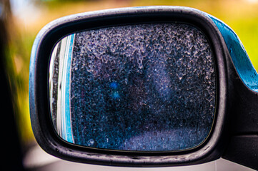 The dust of the road sticks in the car mirror