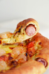 Close up photo of sausage crust pizza in white background