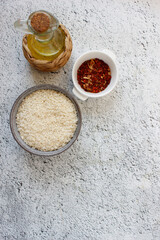 ingredients for paella. grey bowl with rice on background with copy space for your text, top view. Natural food high in protein