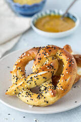 Close up of a homemade baked pretzel topped with everything seasoning.
