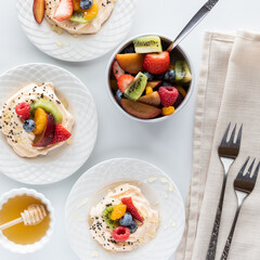 Top down view of homemade meringues topped with fresh fruit salad. 