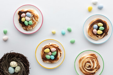 Top down view of homemade toasted meringues with chocolate eggs in the middle.