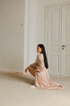 Stylish and fashionable girl with clean skin and Asian appearance in a bright interior