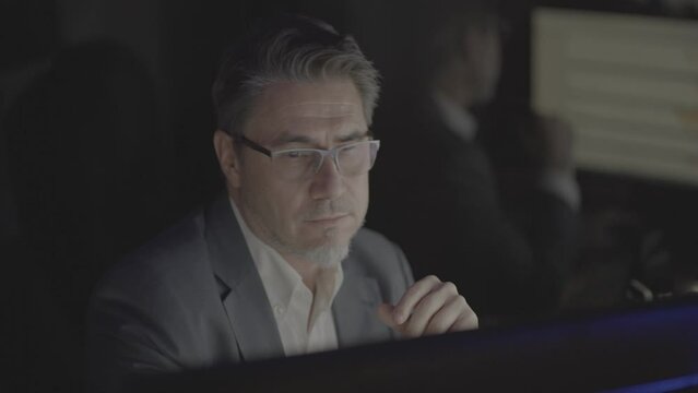 Businessman working with computer at office desk, thinking, smiling. Portrait of happy mid adult man in shirt and jacket, smiling. Video in LOG format - S-LOG3 Cine.