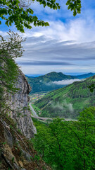 Fototapeta na wymiar Massive rock formation and a scenic view from below mount Roethelstein near Mixnitz in Styria, Austria. Landscape of green alpine meadow in the valley of Grazer Bergland in Styria, Austria. Street