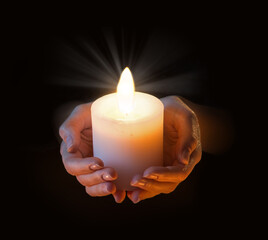 Women's hands holding a candle