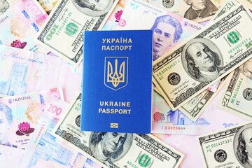 Passport of Ukraine, a document for traveling abroad against the background of banknotes of the national currency and dollars, top view, flatley, the concept of preparing for a trip, tourism, a trip o