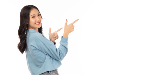 Beautiful young Asian woman pointing up to copy space and looking at camera with smile face and...