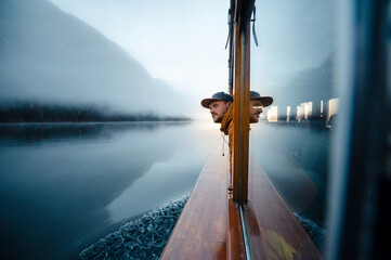 Side view of man floating on boat on lake Konigsee