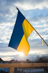 Ukrainian flag flutters in the wind and sunlight against the sunset sky. National symbol of freedom and independence.. Russia's invasion of Ukraine, Stop the war. Hope and Faith