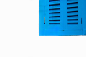 Wooden window with blue shutters on white wall