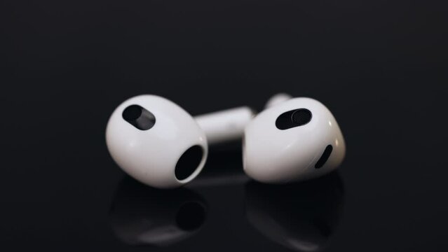 Wireless earphone with noise cancelling technology. Shallow Depth of field. Wireless headphones with charging case. Bluetooth headphones isolated on black background. Gadgets and electronic devices.