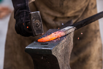 A Sword smith shaping a blade on an anvil