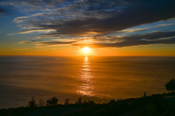 Fototapeta na wymiar Sun setting into the Pacific Ocean in Big Sur California