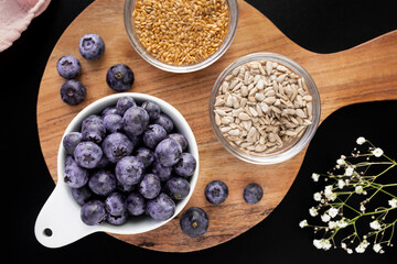 Bowl with fresh blueberries, sunflower seeds and flax seeds
