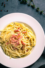 Linguine carbonara on black background