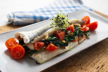 Baked sea bass stuffed with spinach, raisins and pine nuts.
